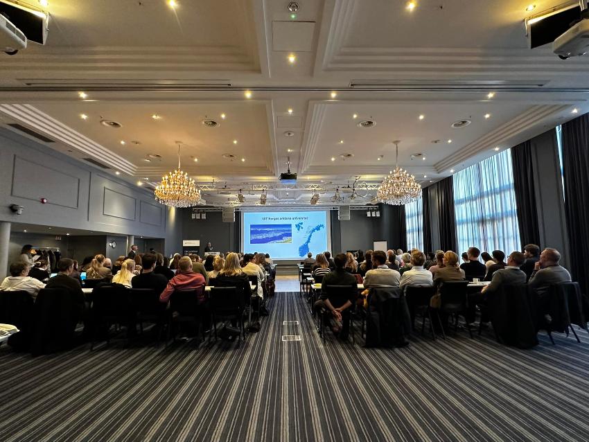 Bilde av deltakerne på konferansen, mens de nøye følger med på en presentasjon. 