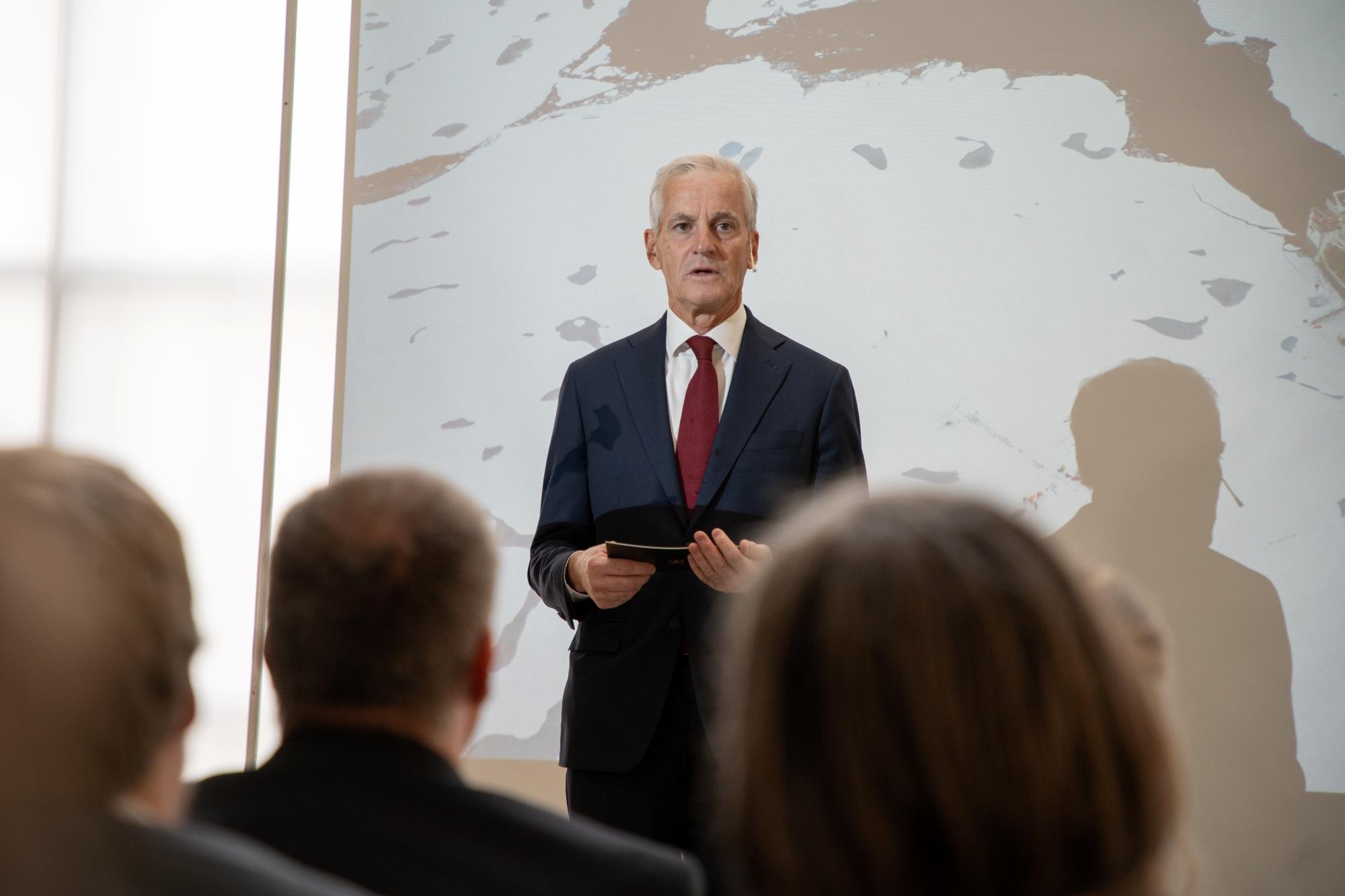 En person st&aring;r og snakker foran flere mennesker