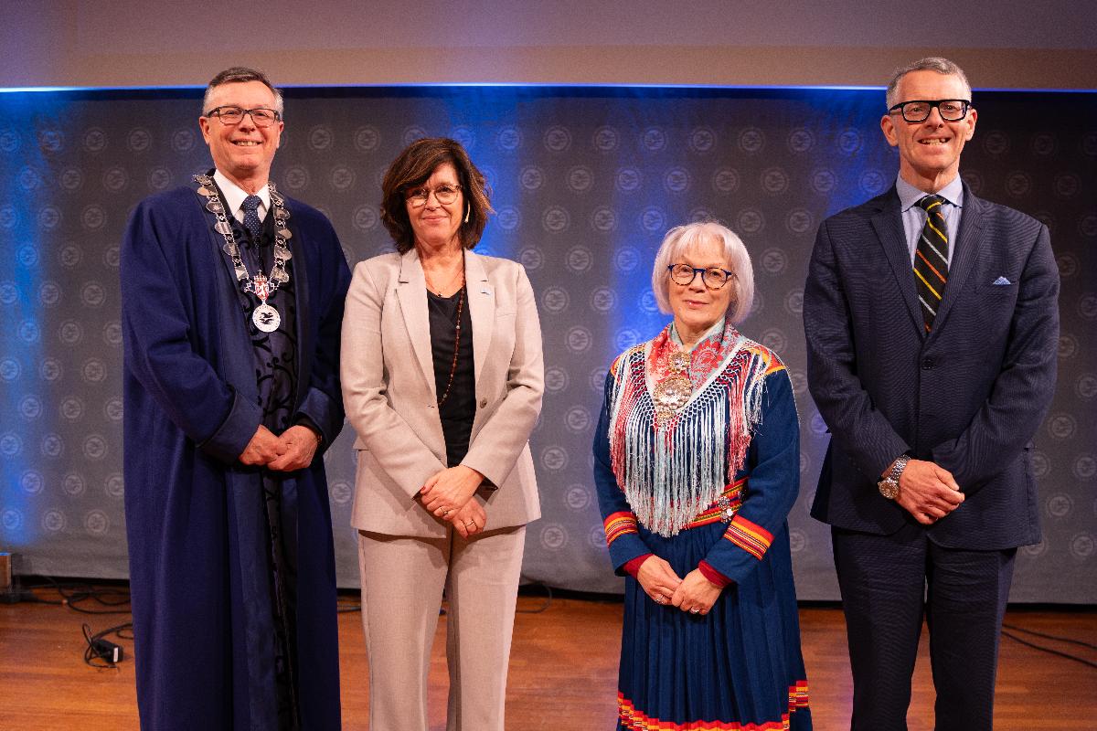 Fire personer p&aring; scene, der en hedres med &aelig;resdoktortittel