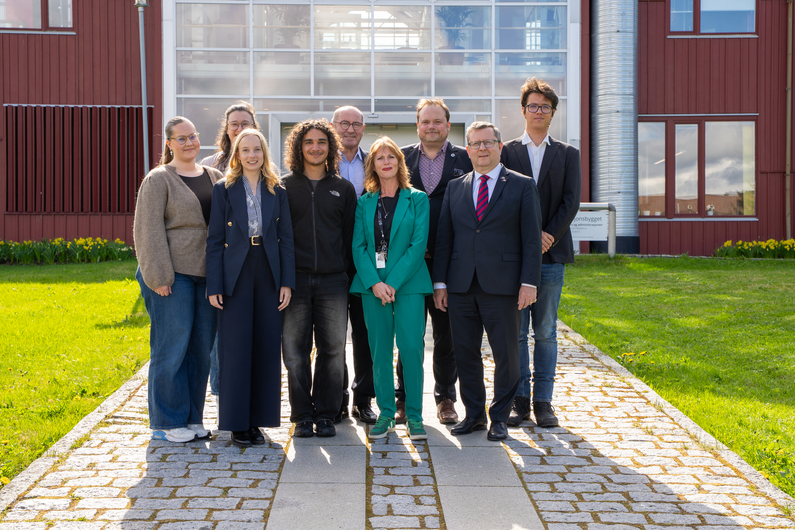 4.jpg Gruppefoto ved en plen og stor bygning.