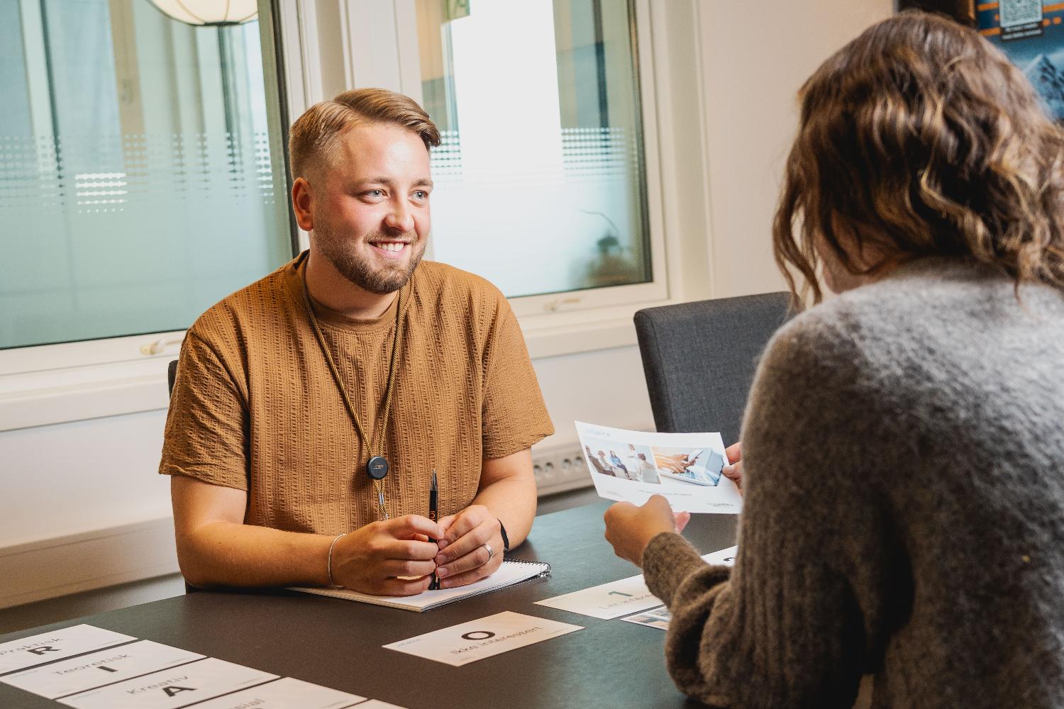  To personer sitter og prater i lag på kontor